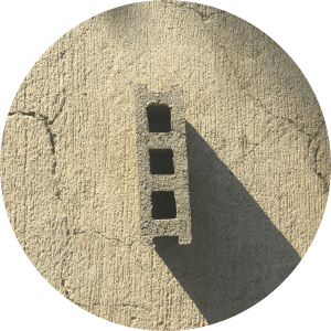 A three-holed size five hollow block on pavement.